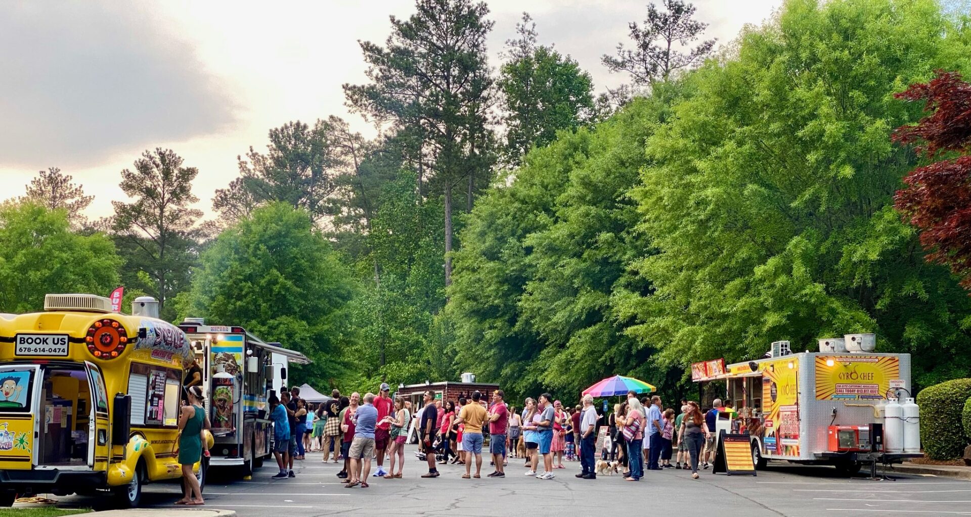 Food Trucks lining street with people standing in line at DHA Food Truck Thursdays in Dunwoody, Ga