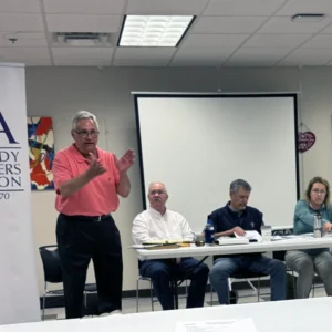 man talking in front of board at a Dunwoody Homeowners Association board meeting