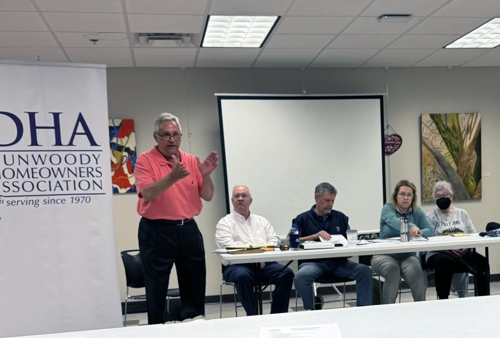 man talking in front of board at a Dunwoody Homeowners Association board meeting